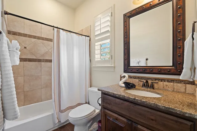 a bathroom with a granite countertop sink toilet and shower