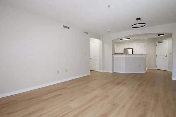 a view of empty room with wooden floor