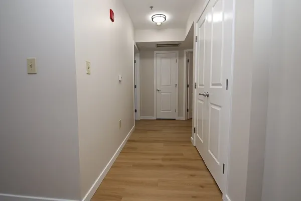 a view of a hallway with wooden floor and staircase