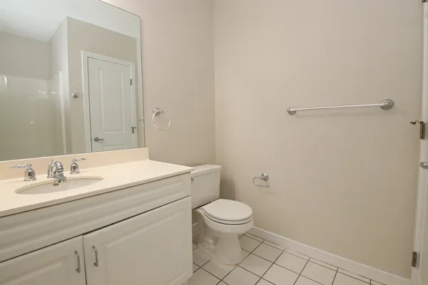 a bathroom with a granite countertop sink mirror vanity and toilet