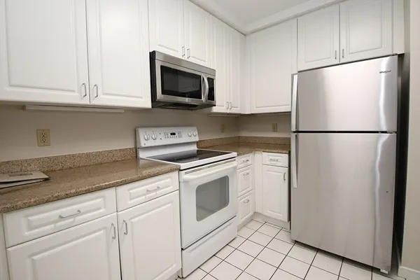 a white refrigerator freezer and a stove sitting inside of a kitchen