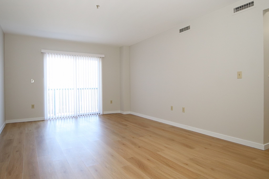 175 Cottage Street, Unit 501 Chelsea, MA 02150 - Photo 9 of 42 a view of an empty room with wooden floor and a window