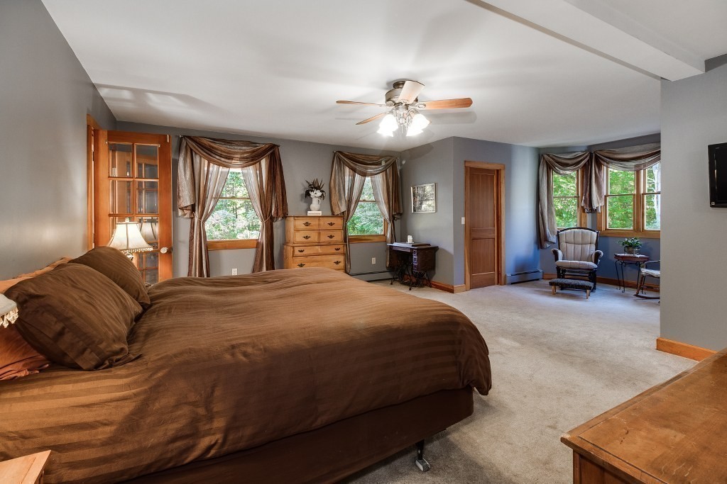 67 Campbell Street Rutland, MA 01543 - Photo 14 of 30 a spacious bedroom with a large bed and a chandelier