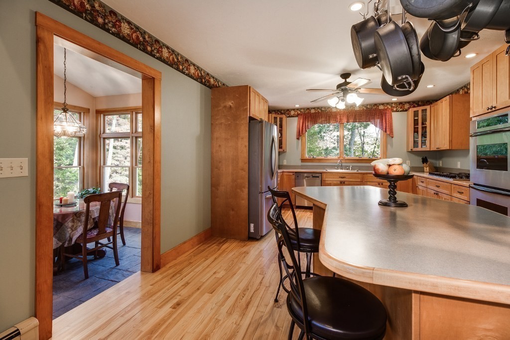 67 Campbell Street Rutland, MA 01543 - Photo 8 of 30 a kitchen with stainless steel appliances granite countertop a stove a refrigerator a dining table and chairs with wooden floor