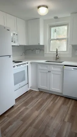 a kitchen with granite countertop white cabinets and white appliances