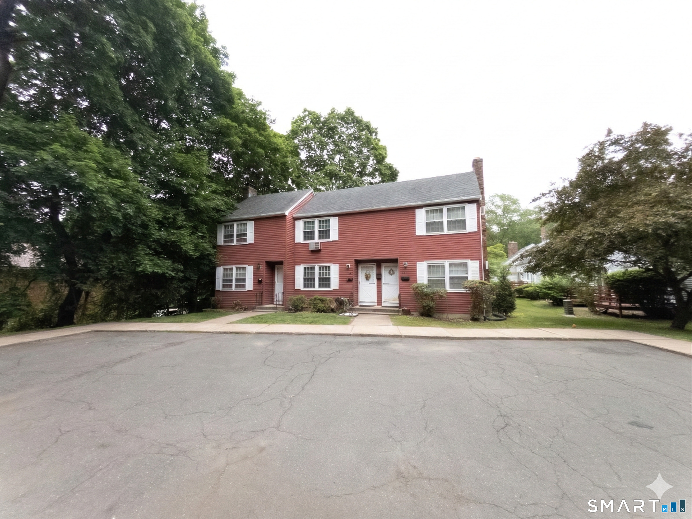 front view of a house with a yard and trees