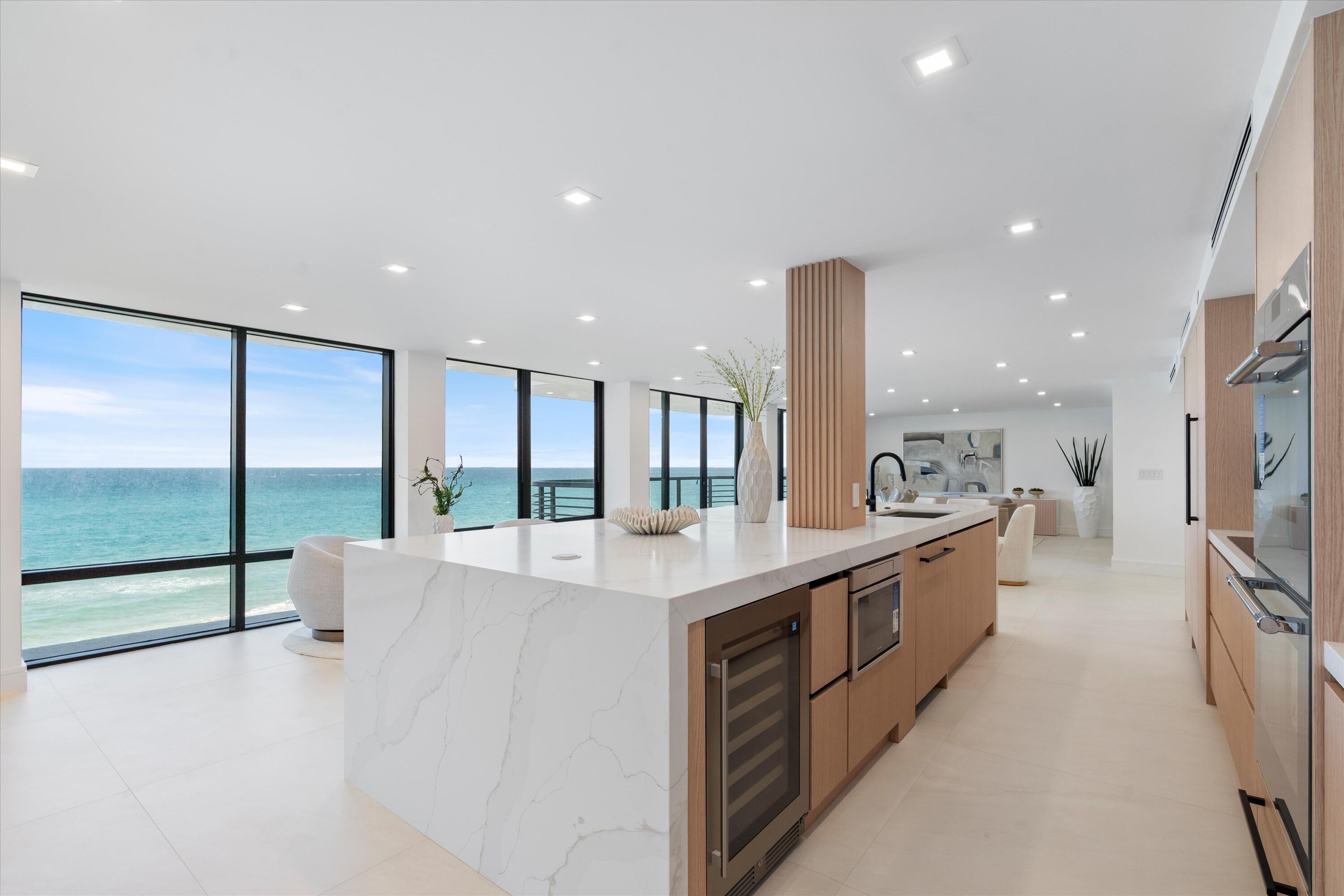 a large kitchen with stainless steel appliances a large counter top a stove a chimney a sink and a refrigerator