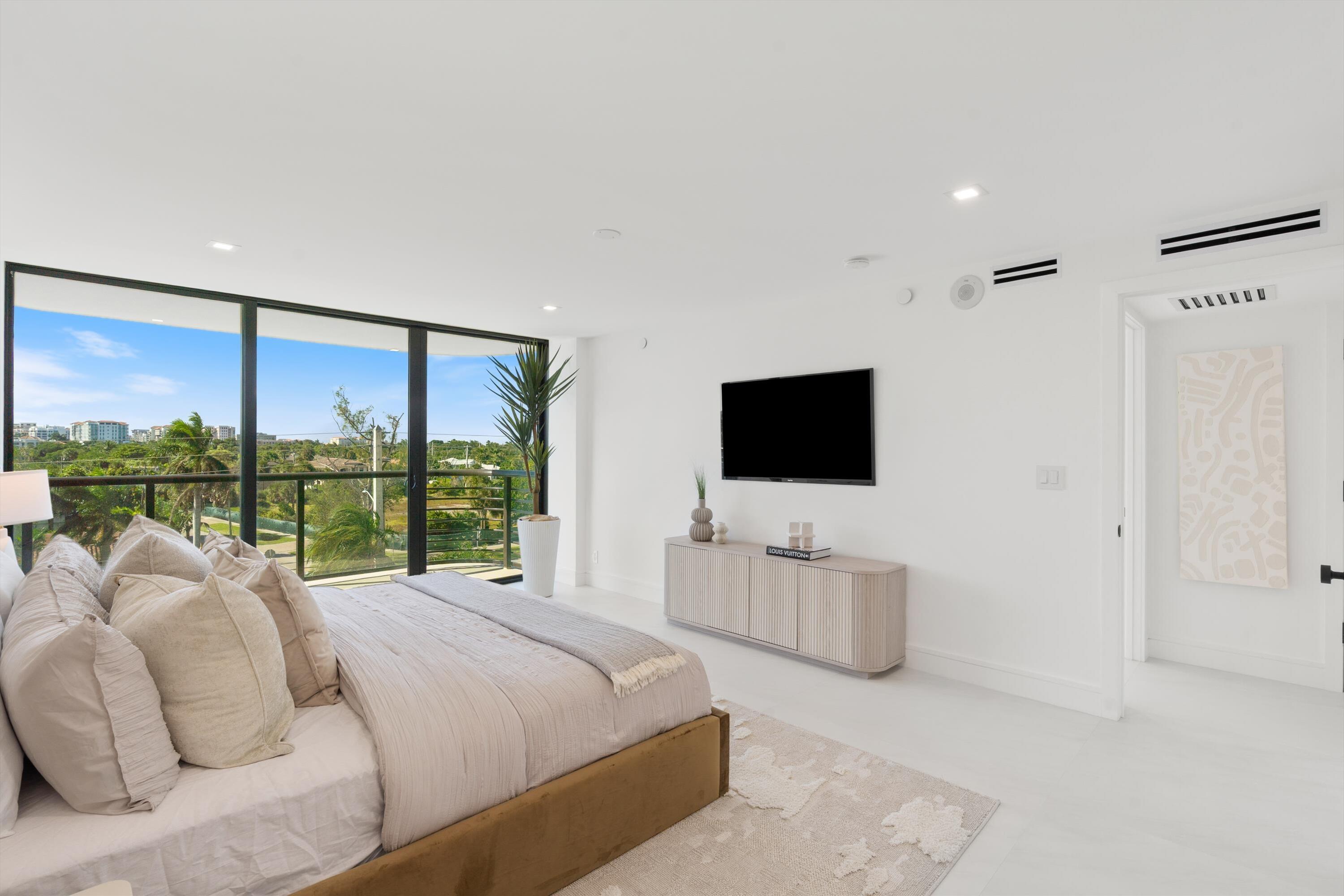 250 South Ocean Boulevard, Unit 3E & 3F Boca Raton, FL 33432 - Photo 18 of 46 a bed room with a bed television and a large window