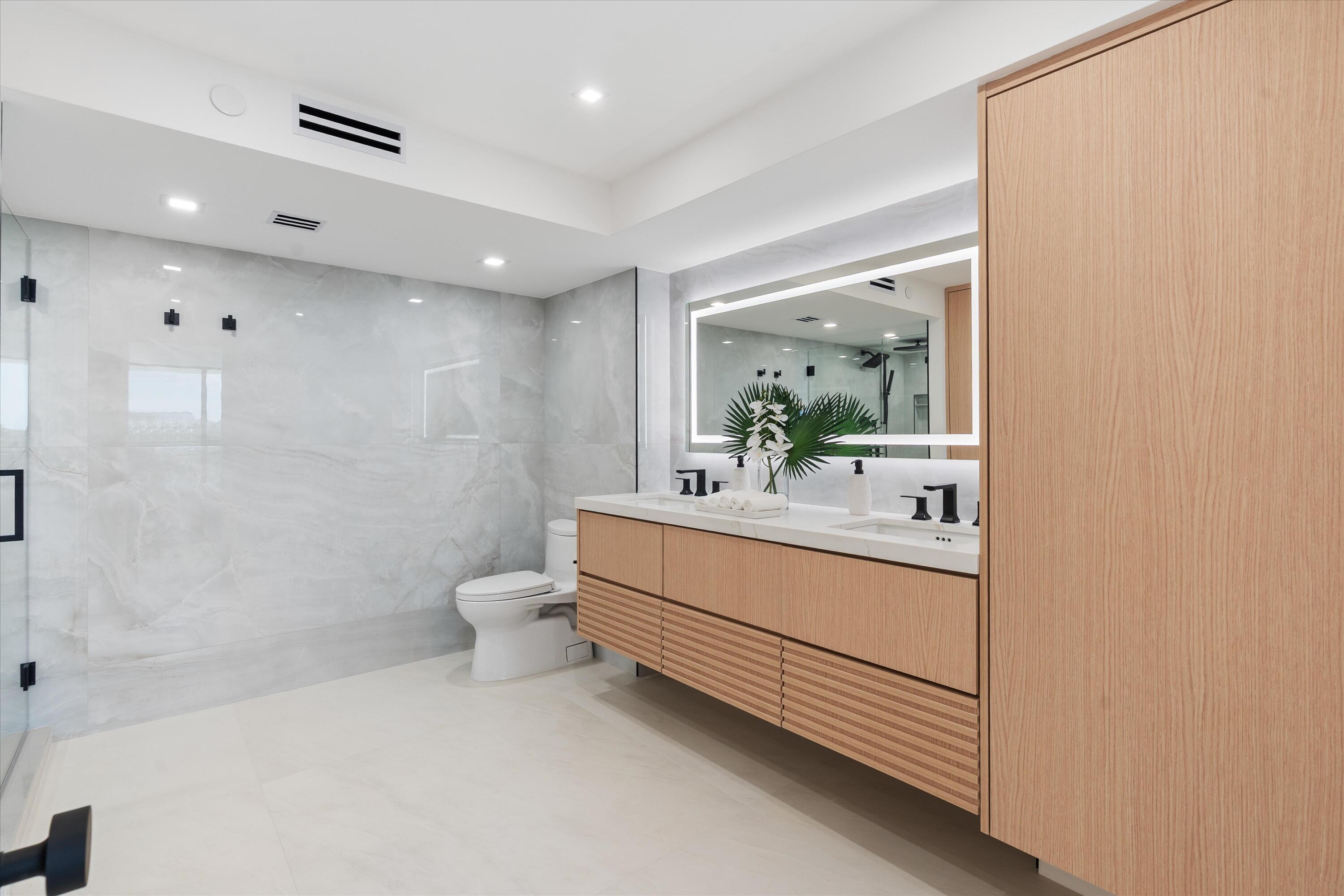 250 South Ocean Boulevard, Unit 3E & 3F Boca Raton, FL 33432 - Photo 19 of 46 a bathroom with a sink a toilet and shower