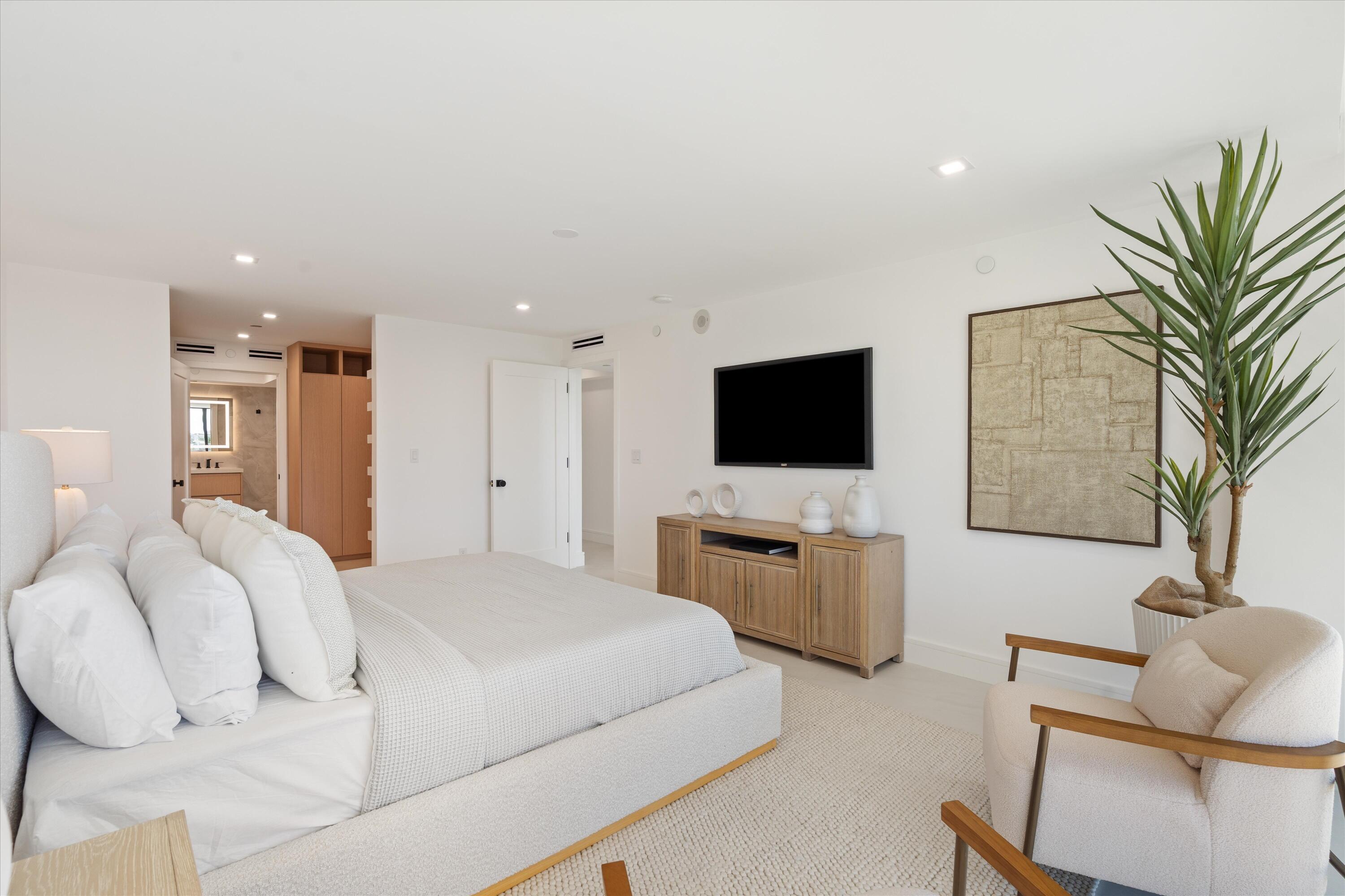 250 South Ocean Boulevard, Unit 3E & 3F Boca Raton, FL 33432 - Photo 22 of 46 a bedroom with furniture and a flat screen tv