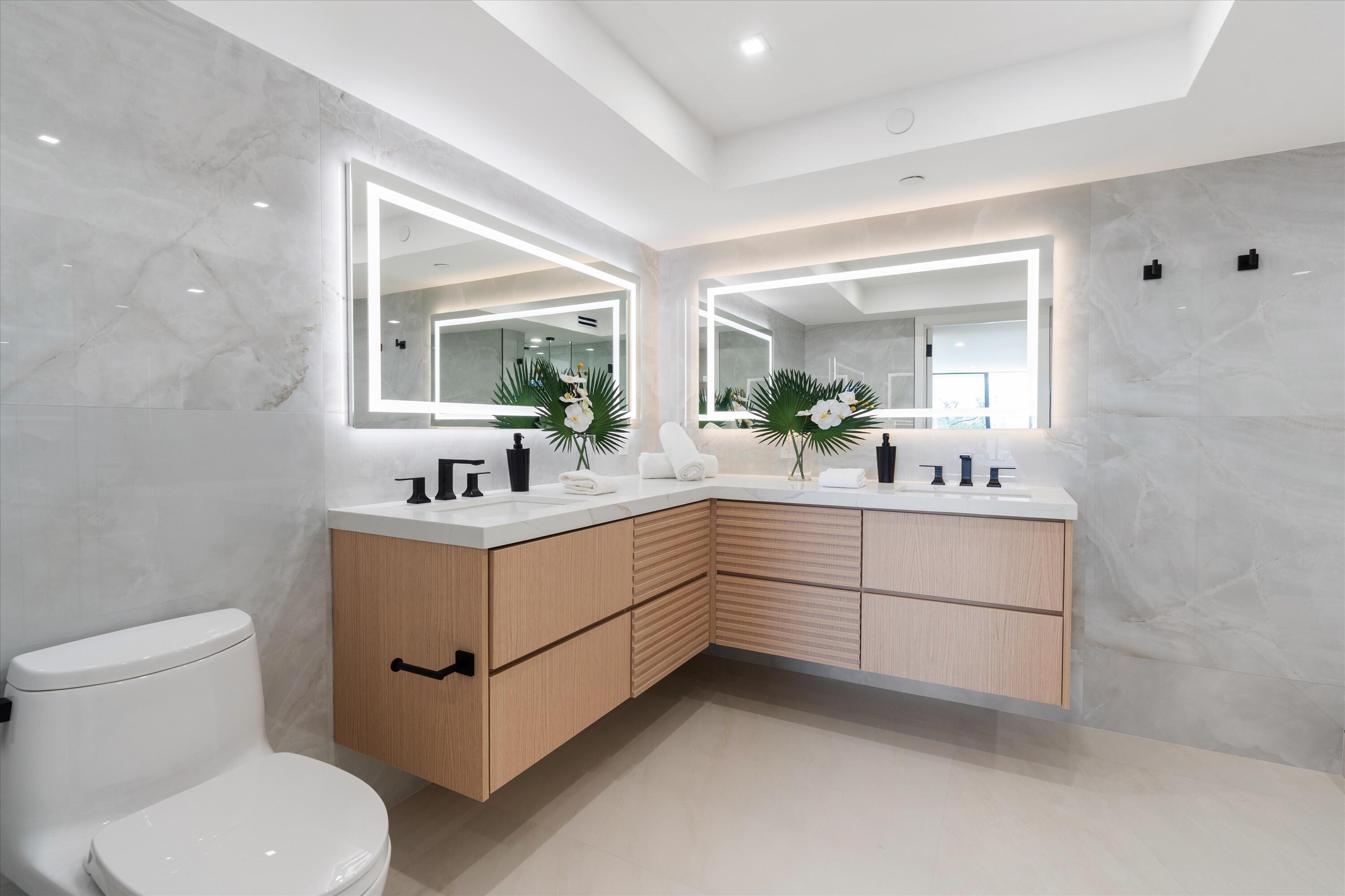 250 South Ocean Boulevard, Unit 3E & 3F Boca Raton, FL 33432 - Photo 23 of 46 a bathroom with a sink vanity and mirror