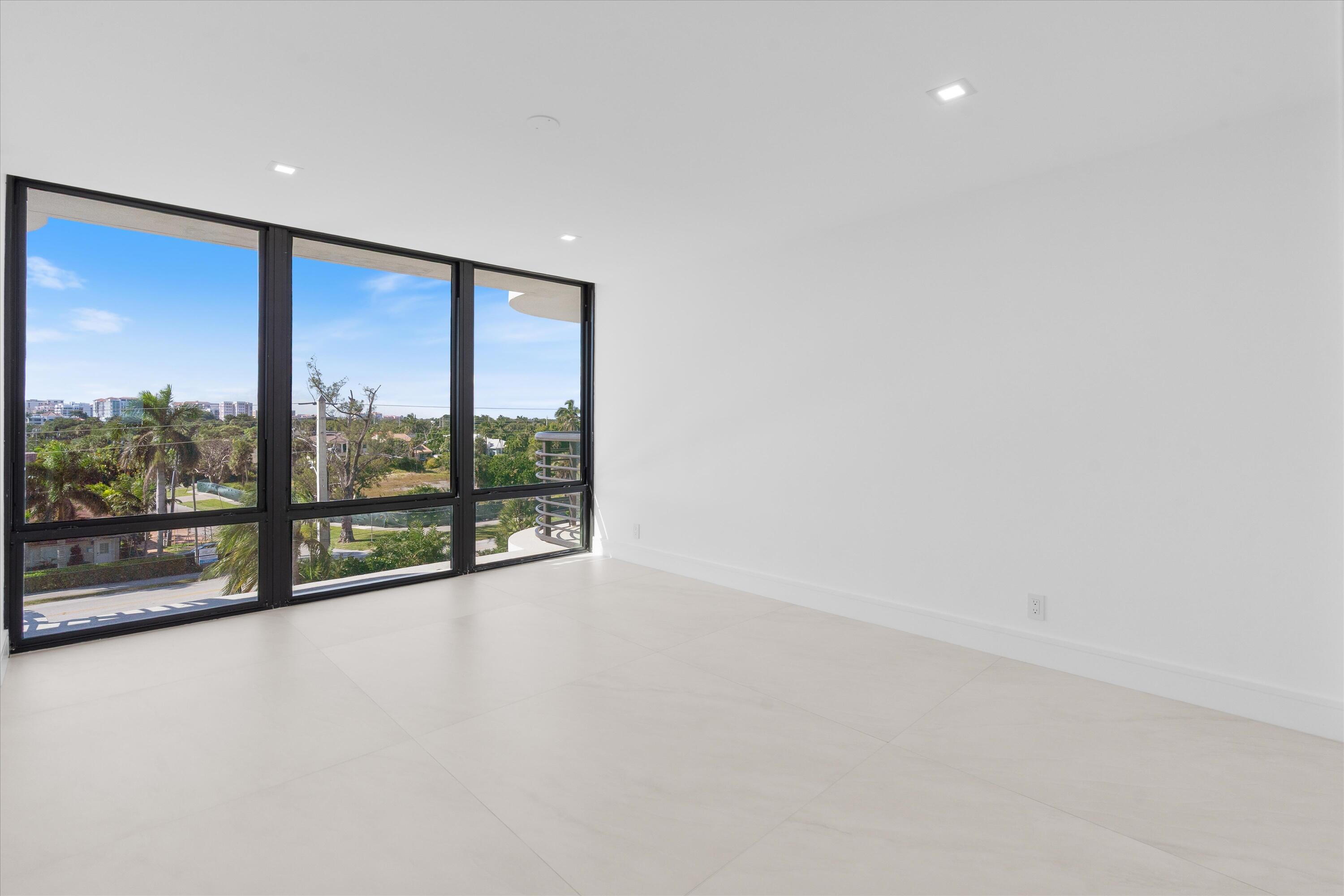 250 South Ocean Boulevard, Unit 3E & 3F Boca Raton, FL 33432 - Photo 28 of 46 an empty room with wooden floor and windows with city view
