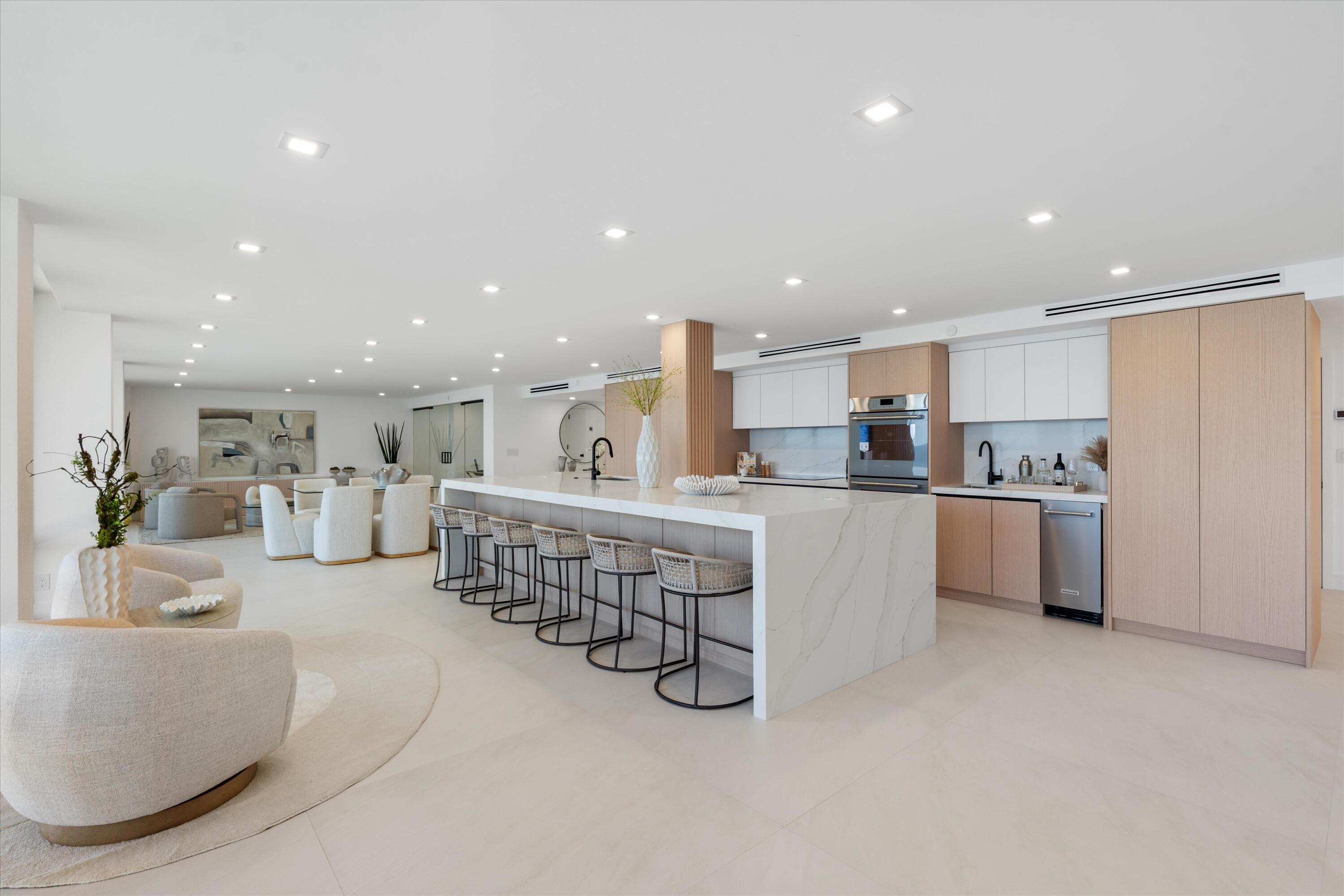 250 South Ocean Boulevard, Unit 3E & 3F Boca Raton, FL 33432 - Photo 5 of 46 a kitchen with stainless steel appliances kitchen island granite countertop a refrigerator a stove a sink and a dining table with white cabinets