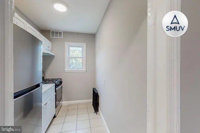 a view of a hallway to a hallway with front door