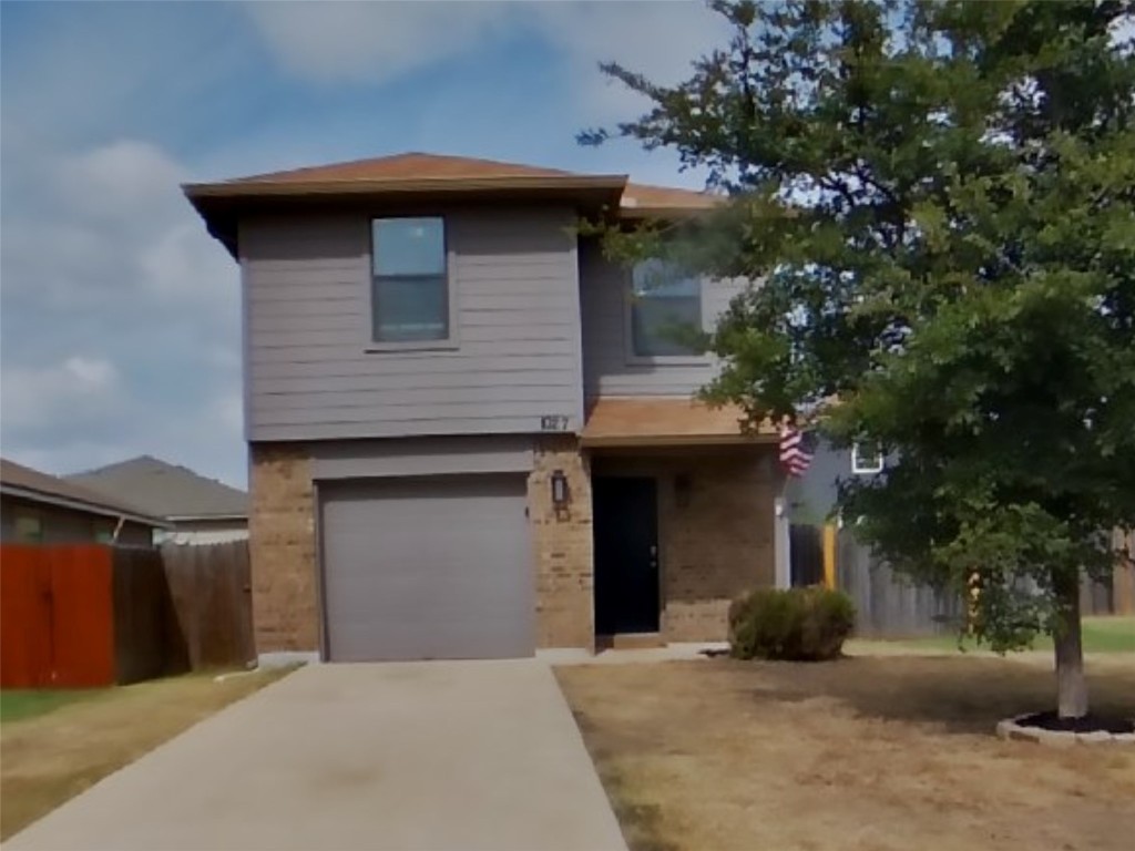 Traditional-style home featuring concrete driveway and a garage