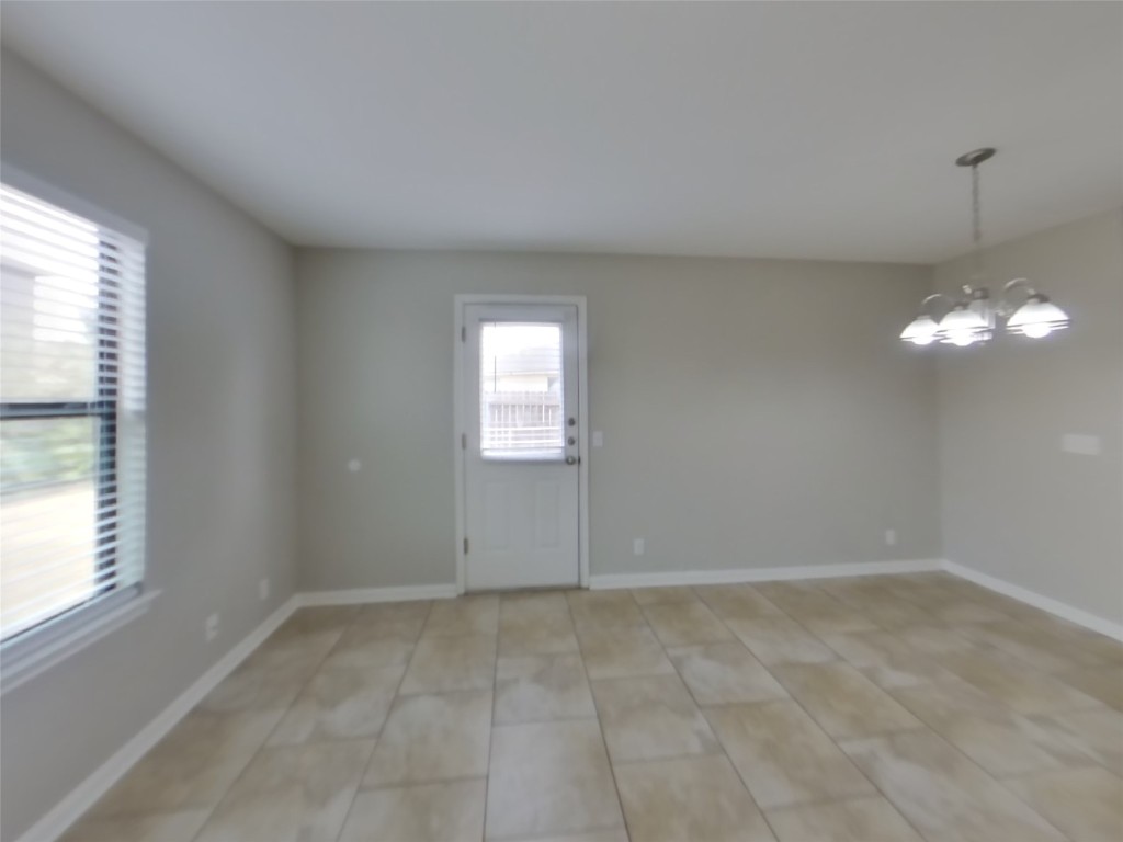 1027 Trail Driver Cove Georgetown, TX 78626 - Photo 3 of 17 Spare room with a chandelier and light tile patterned floors