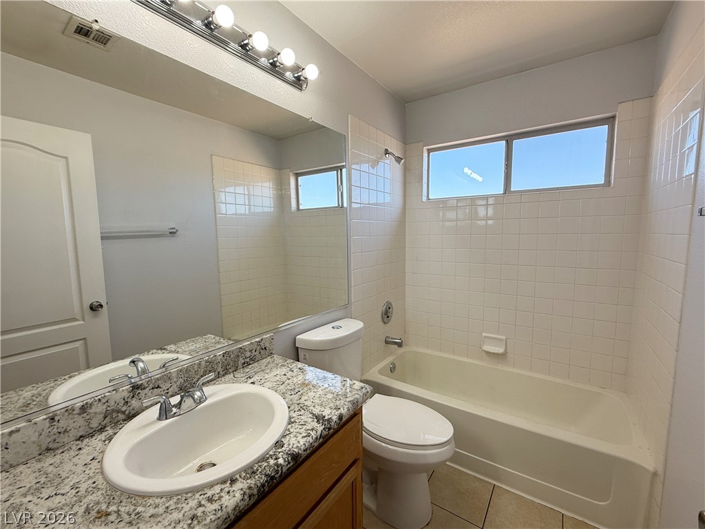 2185 Polynesia Circle Henderson, NV 89074 - Photo 20 of 37 A well-appointed bathroom features a bathtub, toilet, and granite vanity, offering practicality and comfort.
