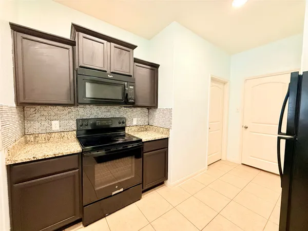 a kitchen with a sink a stove top oven a counter space and cabinets