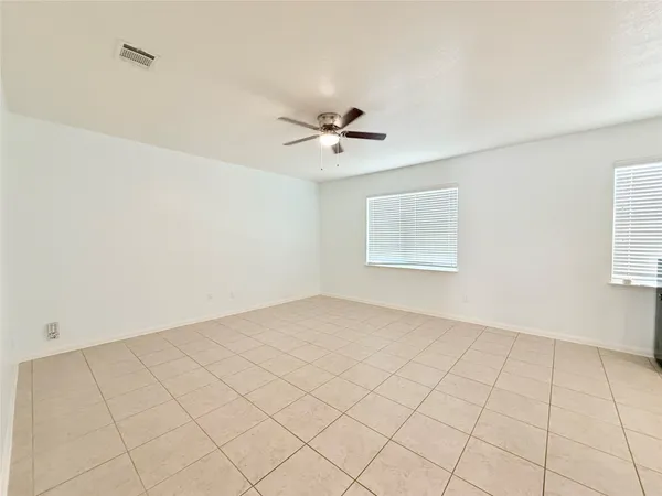 a view of a refrigerator in kitchen and an empty room