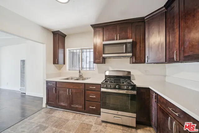 a kitchen with stainless steel appliances granite countertop a stove a sink and a microwave