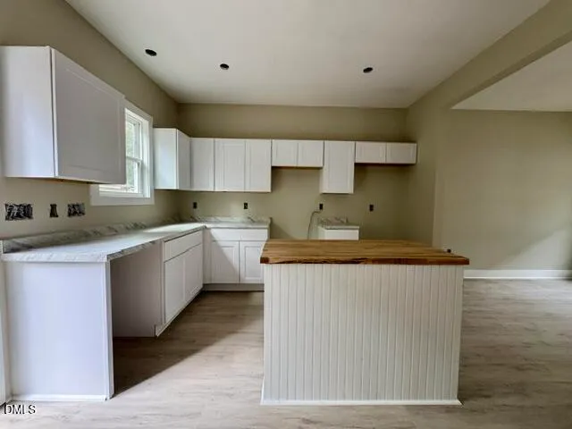 a kitchen with granite countertop a sink a counter top space and cabinets