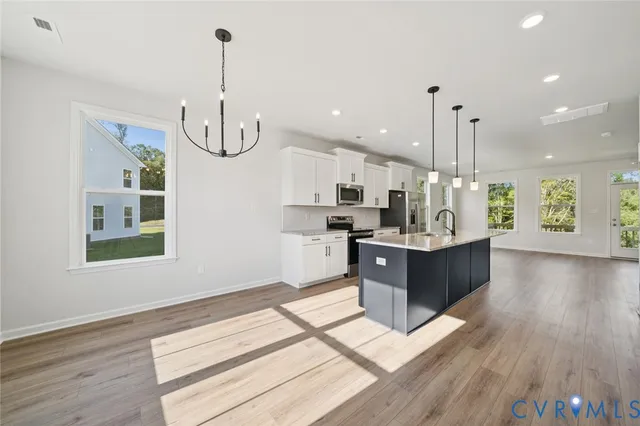 a large kitchen with a lot of counter space and a wooden floor