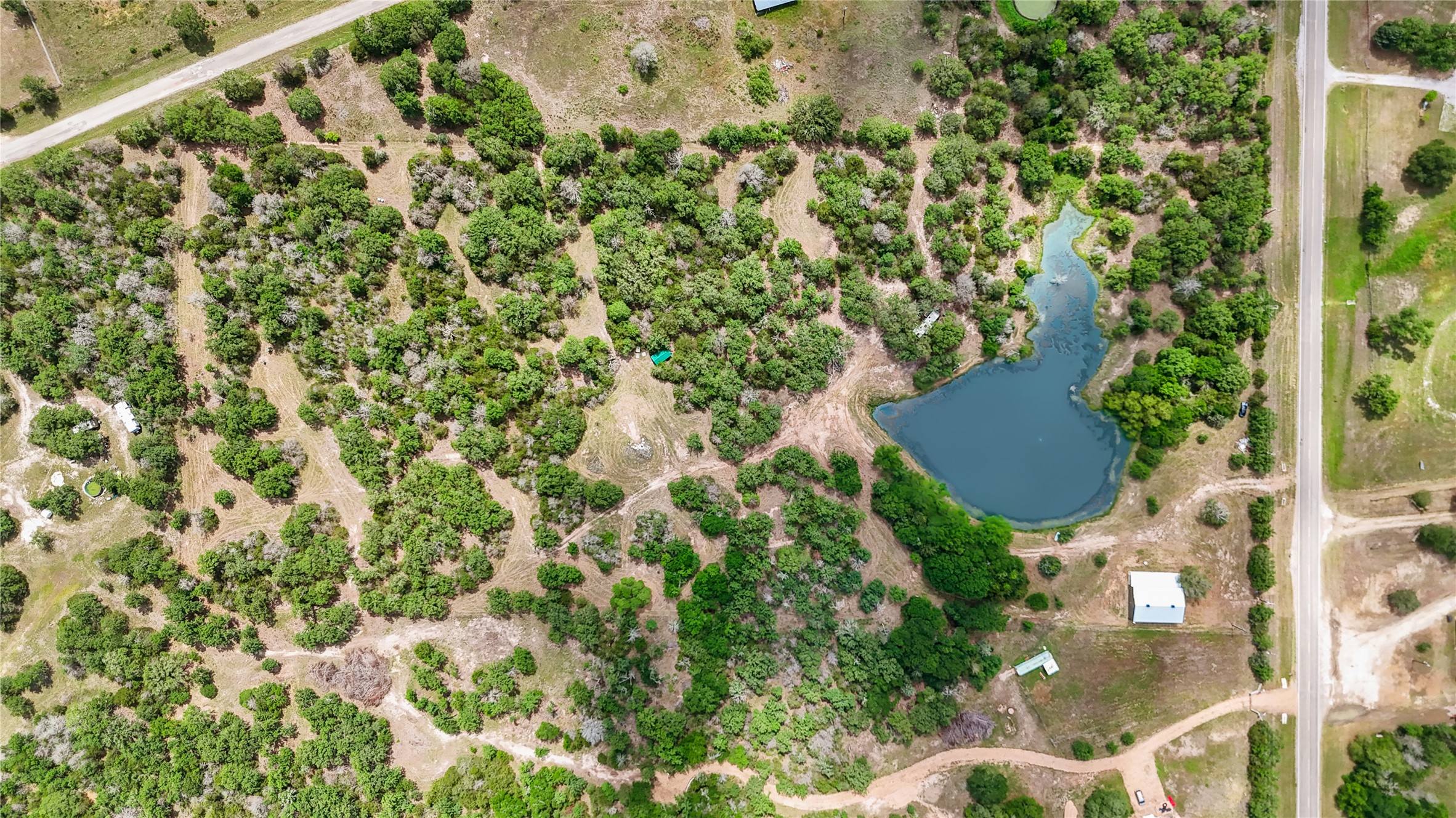 5837 FM 180 Road Ledbetter, TX 78946 - Photo 2 of 16 This aerial photo shows the expansive properties abundant greenery, complete with mulched trails for exploring. The owner has cultivated a park like atmosphere. Take a ride on the side by side and enjoy the serenity of nature.