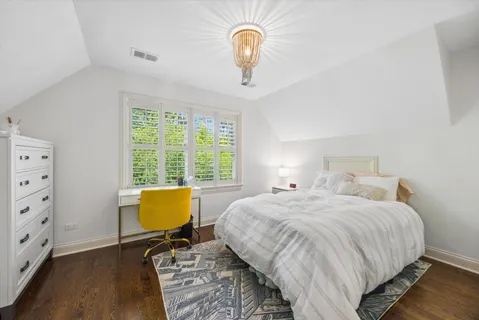 a bedroom with a workspace and a window