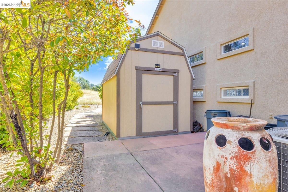 158 Rock Ridge Lane Copperopolis, CA 95228 - Photo 59 of 72 Detached shed with a gambrel roof and double doors, positioned on a concrete pad