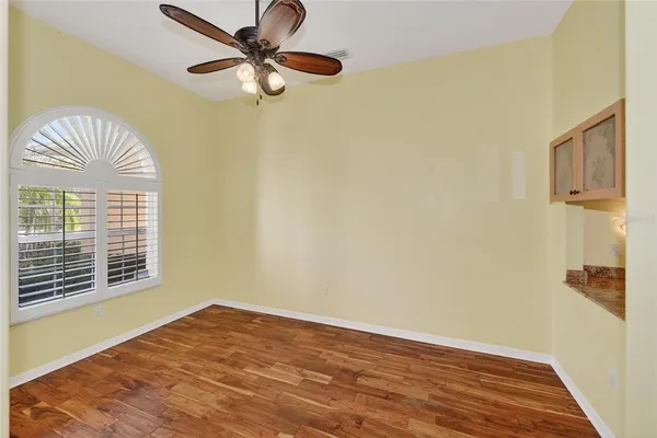 a view of a room with wooden floor and a ceiling fan