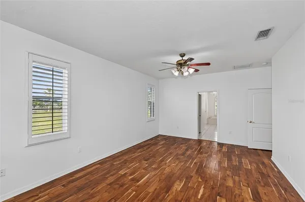 a view of a livingroom with wooden floor and a ceiling fan