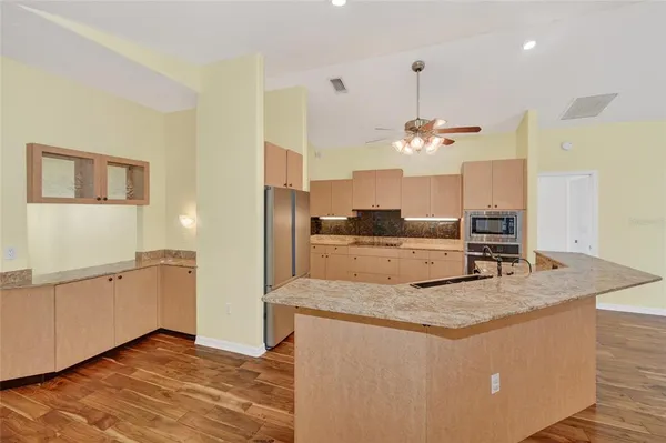a kitchen with kitchen island a counter top space appliances and cabinets
