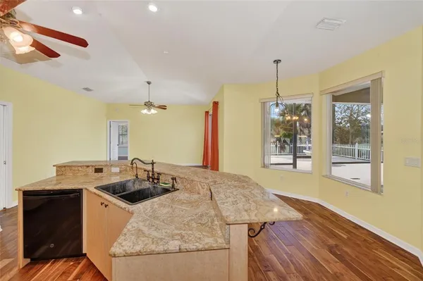 a kitchen with a sink a counter top space and wooden floor