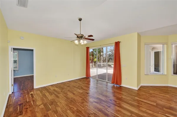 a view of an empty room with window and wooden floor