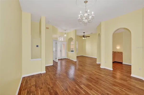 a view of a hallway with wooden floor and chandelier