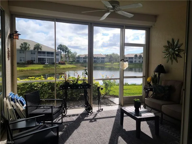 a view of a living room with furniture and floor to ceiling window