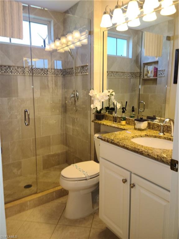 2255 Harmony Lane, Unit 8 Naples, FL 34109 - Photo 7 of 19 a bathroom with a granite countertop sink a toilet and shower