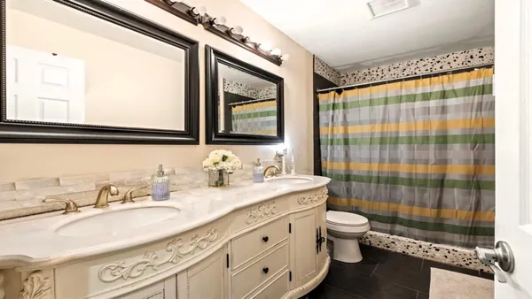 a bathroom with a granite countertop sink a toilet a mirror and shower