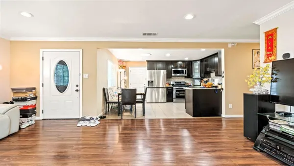 a living room with furniture a wooden floor and a flat screen tv