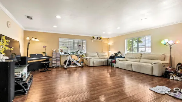 a living room with furniture floor to ceiling window and a wooden floor