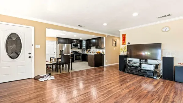 a view of a living room kitchen with furniture and wooden floor