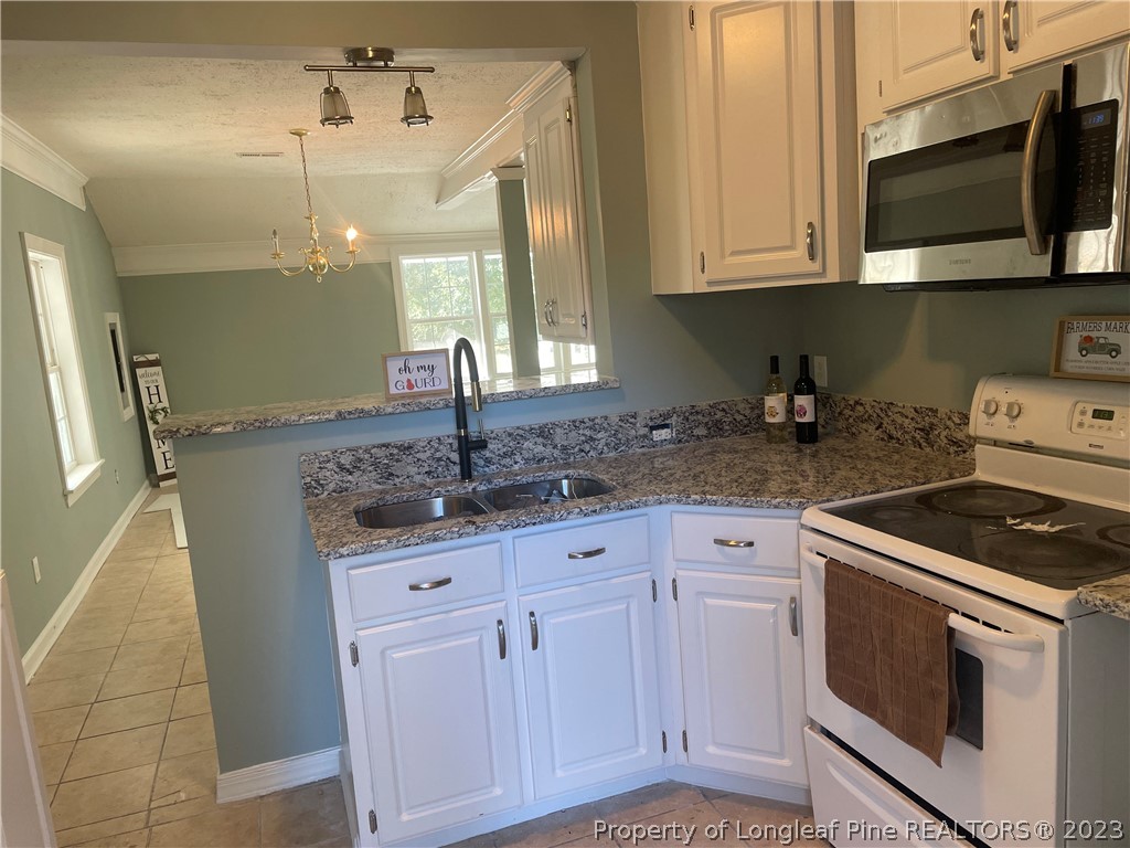 286 Doc Brown Road Raeford, NC 28376 - Photo 7 of 12 a kitchen with stainless steel appliances granite countertop a sink and a stove