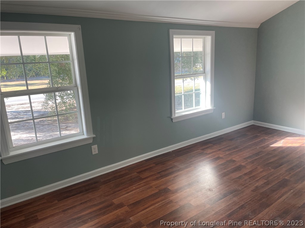 286 Doc Brown Road Raeford, NC 28376 - Photo 9 of 12 an empty room with wooden floor and windows