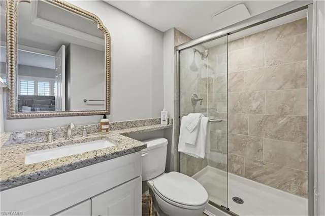 a bathroom with a granite countertop sink toilet and shower
