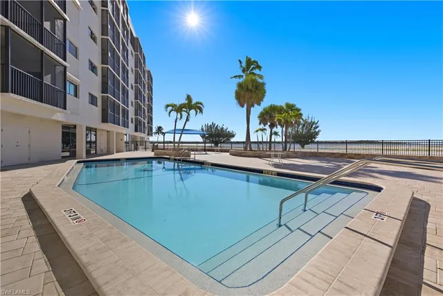 a view of a swimming pool with outdoor seating and plants