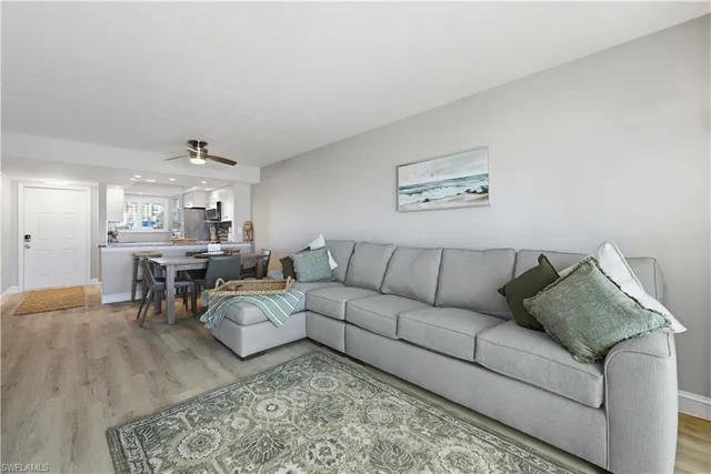 a living room with furniture and a dining table with wooden floor