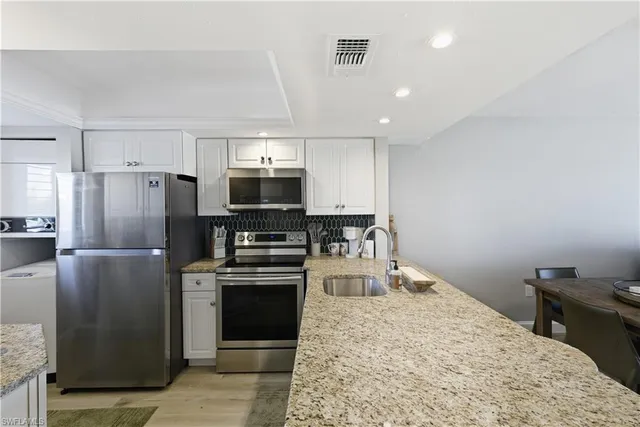 a kitchen with a refrigerator a microwave oven a sink and dishwasher