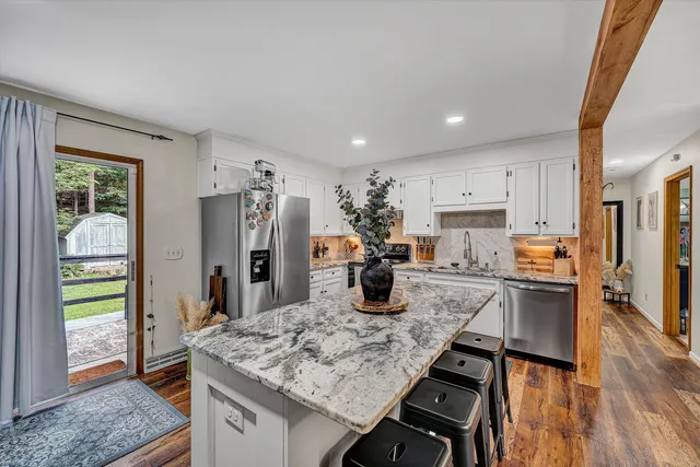 a kitchen with stainless steel appliances granite countertop a sink stove and refrigerator