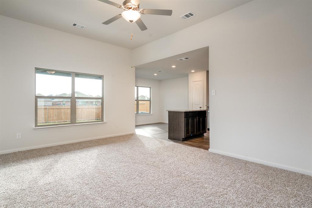232 Micah Lane Ferris, TX 75125 - Photo 12 of 32 an empty room with windows and chandelier fan