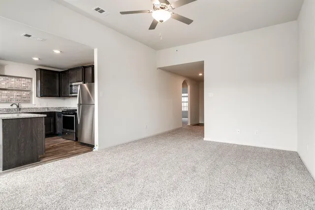 a kitchen with granite countertop a sink stove and refrigerator
